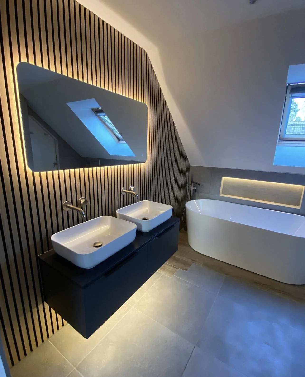 Asymmetrical LED mirror beside a bathroom vanity