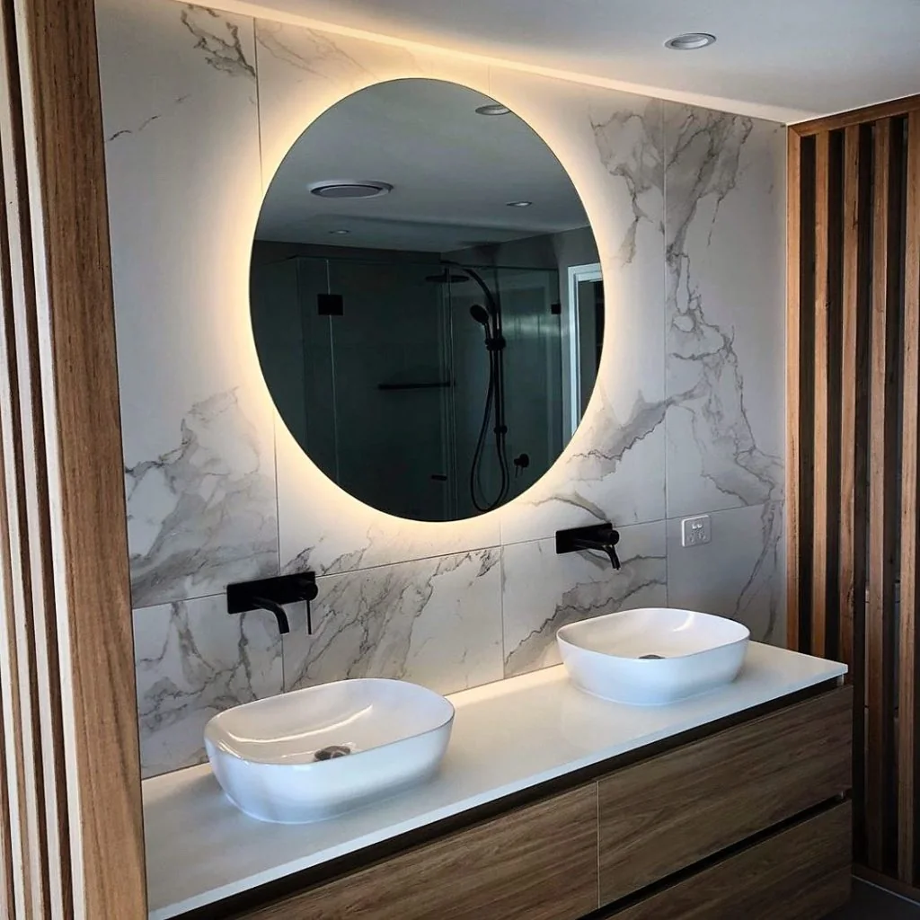 Oval backlit mirror above a vanity