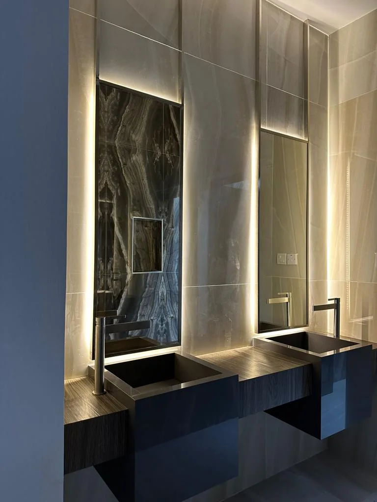 Tall vertical LED mirror beside a vanity