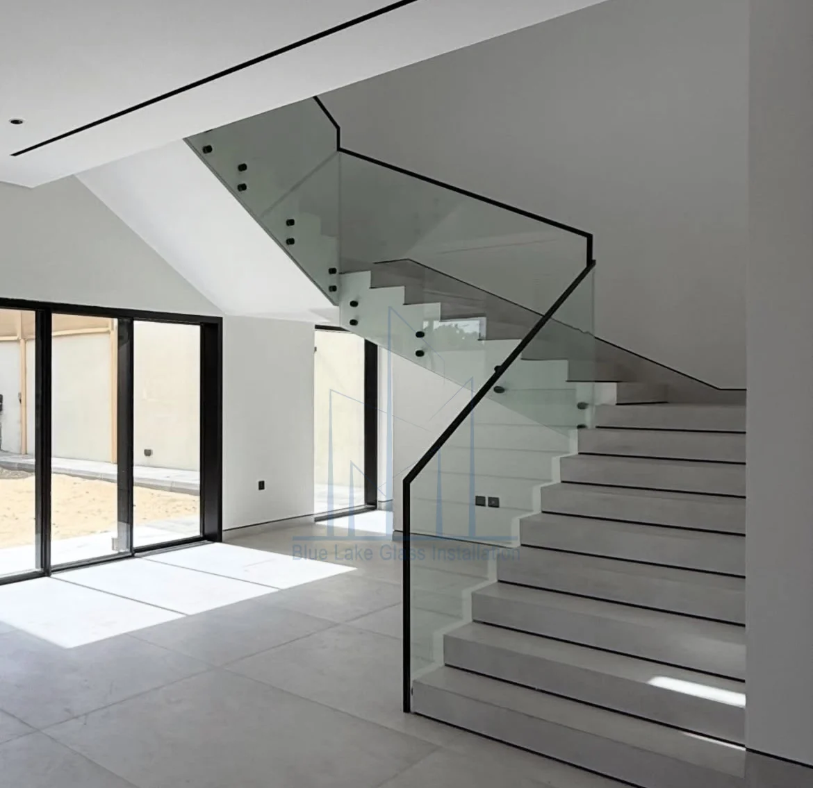 Frameless staircase glass railing with a base channel in a Dubai villa