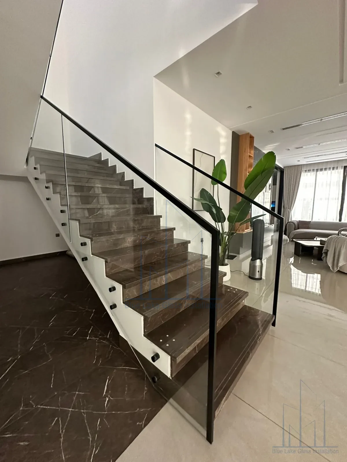 Modern staircase glass balustrade with dark stone steps