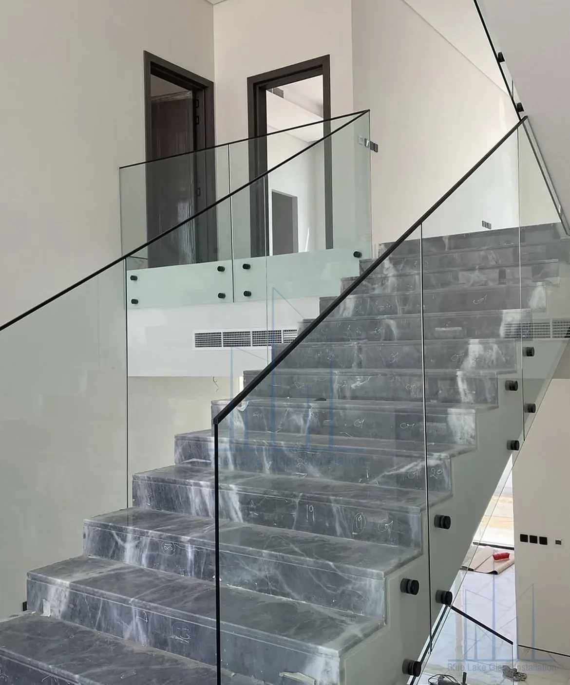 Clear glass railing on a residential staircase landing