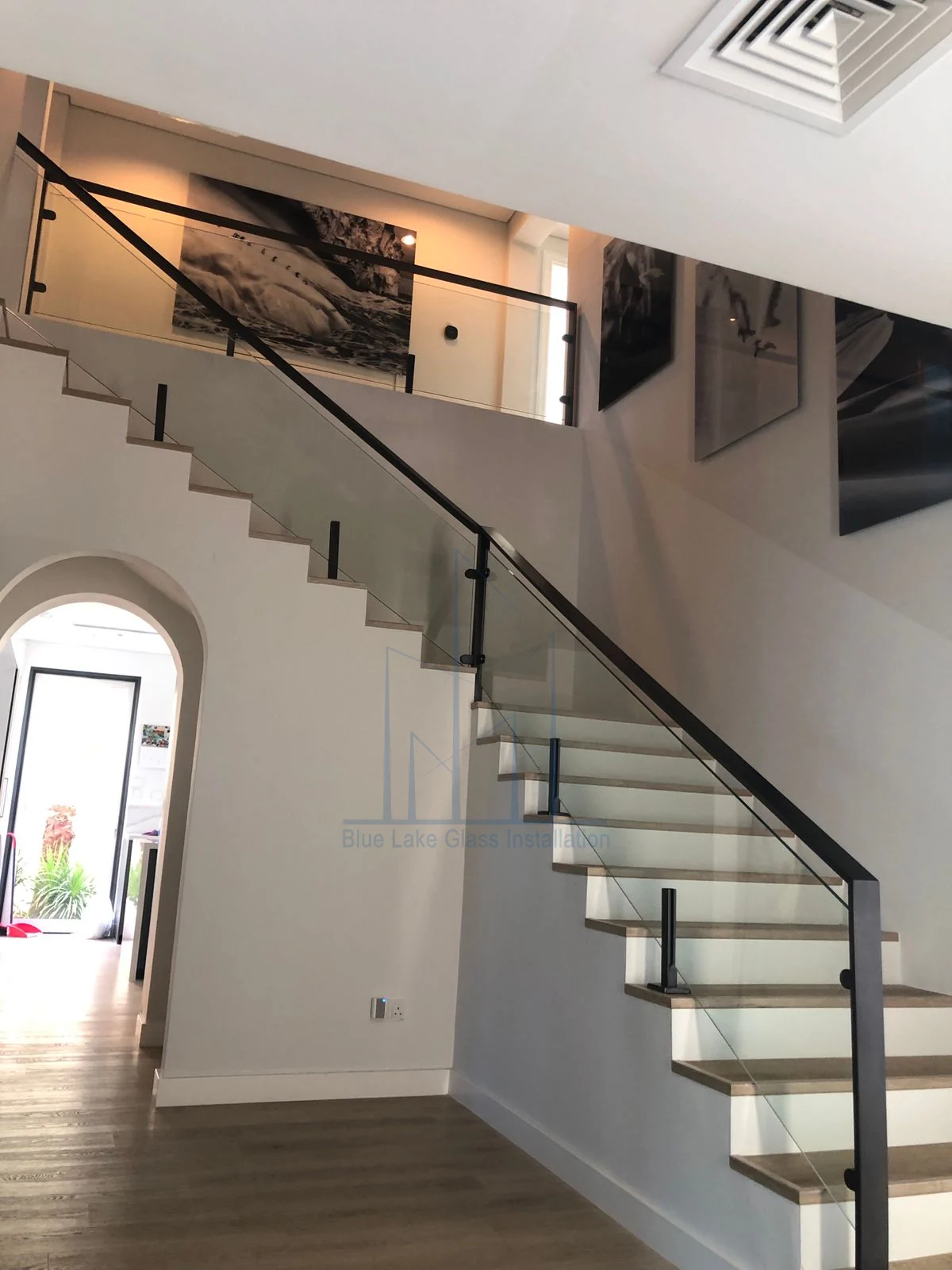 Staircase glass railing with black handrail in a villa interior