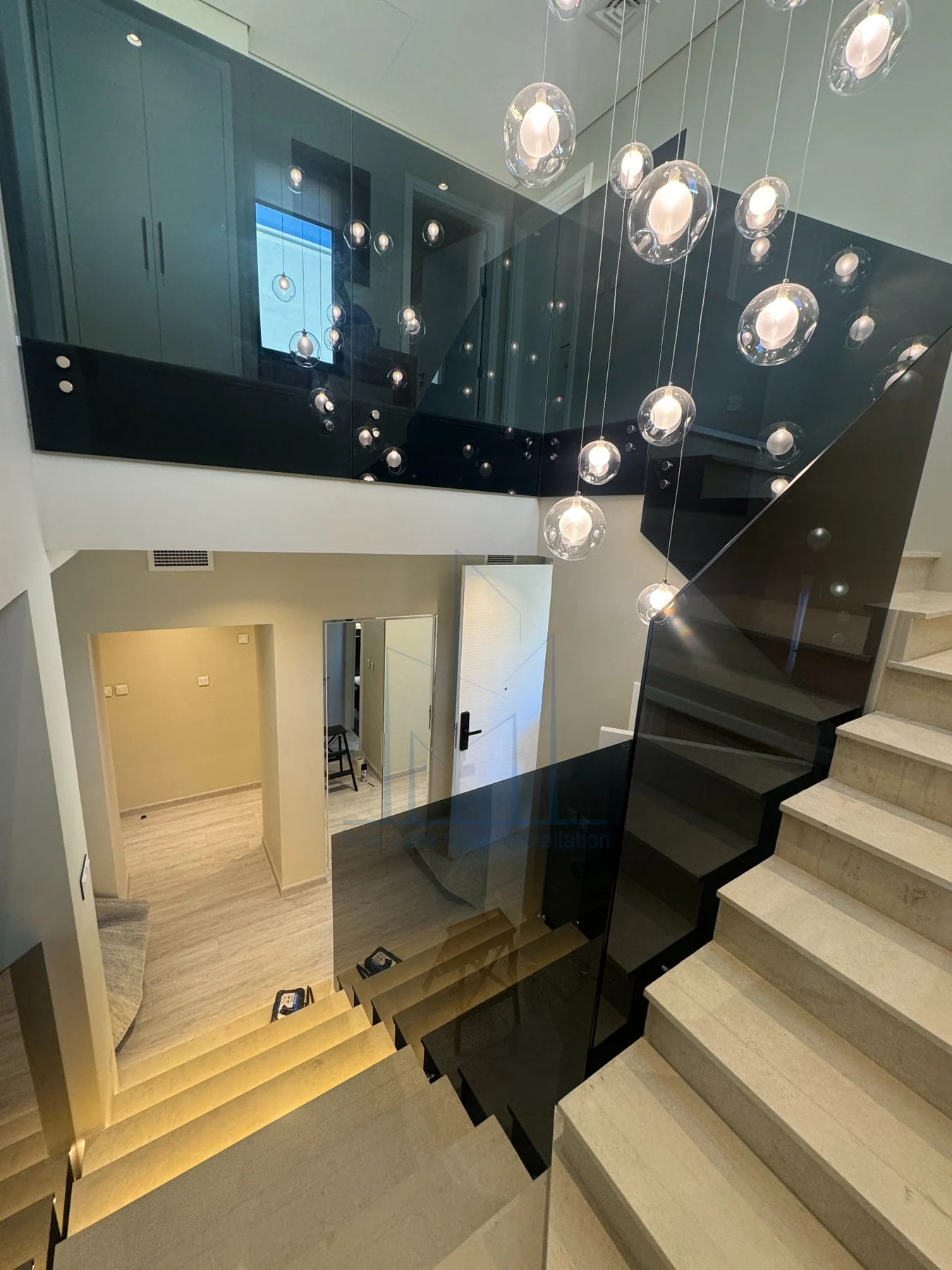 Dark glass railing beside illuminated villa stairs