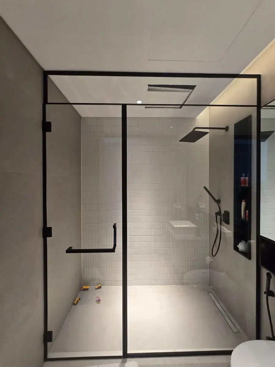 Framed shower glass enclosure with a defined dark profile